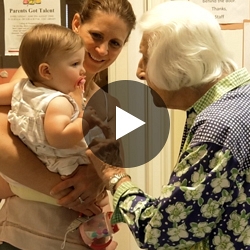 Grandma with daughter and grand child with play button.