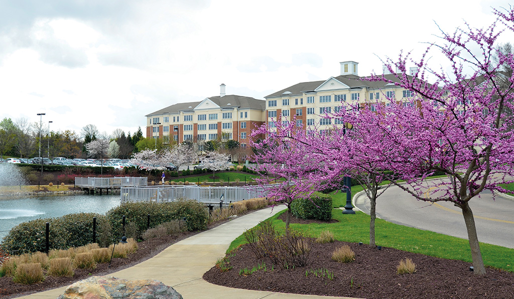 Two apartment buildings with winding path during spring.