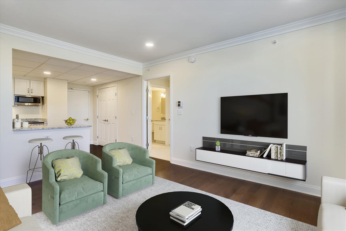 Living area with large tv and bookcase.